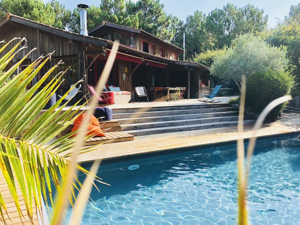 une maison avec une terrasse à côté d'une masse d'eau dans l'établissement La Cabane des pins, à Lège-Cap-Ferret