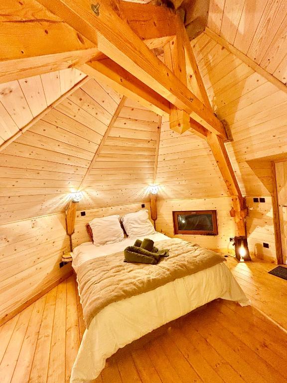 - une chambre avec un lit dans un grenier en bois dans l'établissement La Clé de L Insolite, à Hudiviller