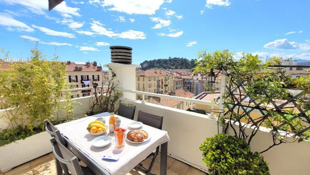 - un balcon avec une table et de la nourriture dans l'établissement Cosy penthouse Le Port 2 BR - 2 Bath, à Nice