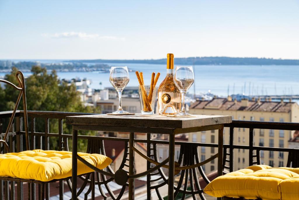 une table avec deux verres à vin sur un balcon dans l'établissement Superbe T3 - 10 min Palais - Parking, à Cannes
