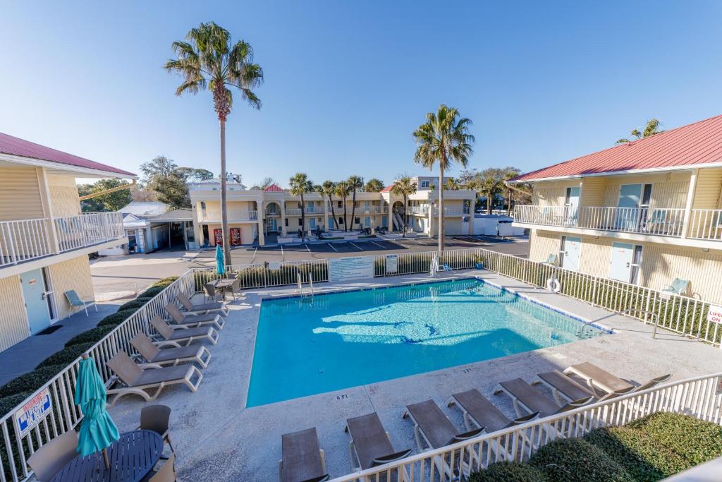 a swimming pool with lounge chairs and a resort at Dunes Inn & Suites - Tybee Island in Tybee Island