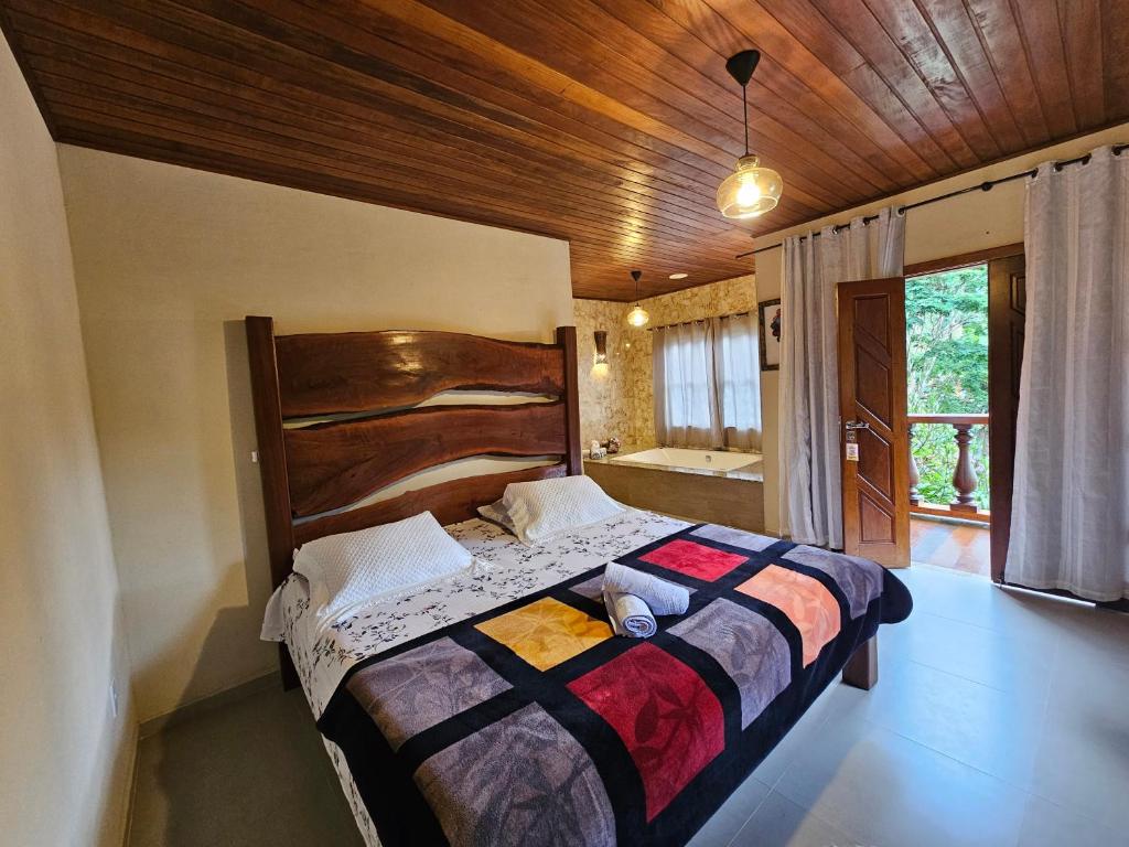a bedroom with a large bed with a wooden headboard at Delícias da Tilápia em Domingos Martins ES in Domingos Martins