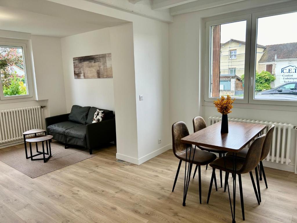 un salon avec une table et un canapé dans l'établissement Appart hôtel Doumer, à Triel-sur-Seine