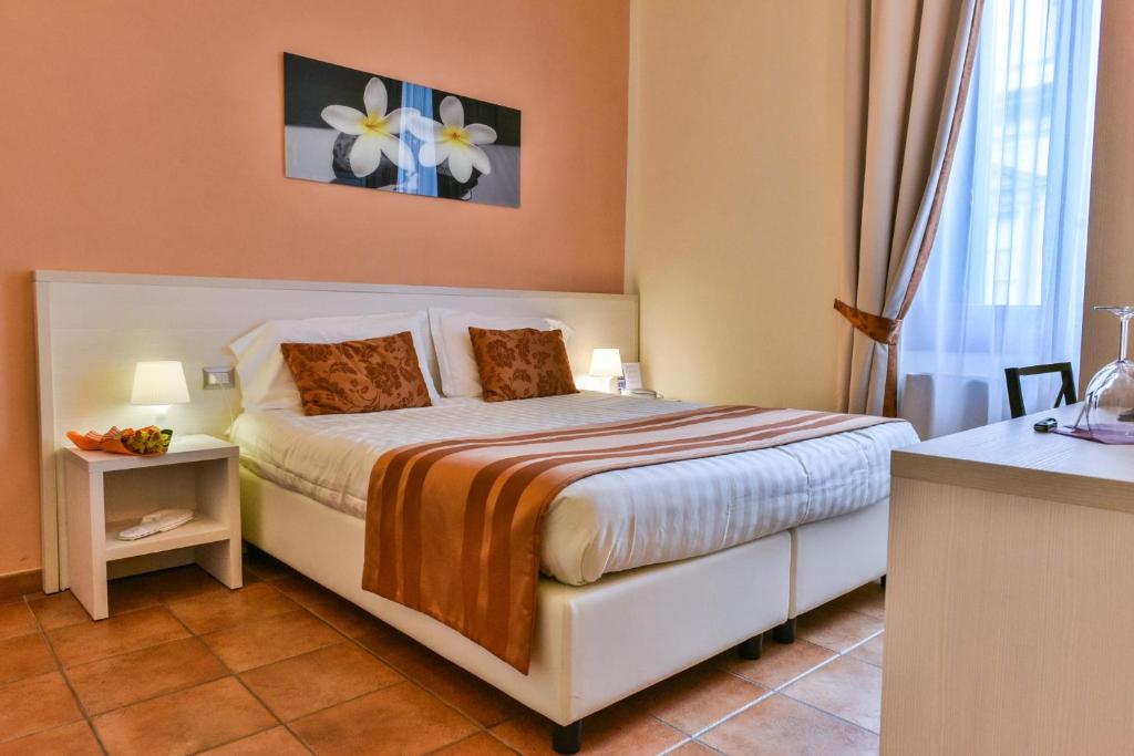 a bedroom with a bed with orange walls at Hotel Bella Firenze in Florence