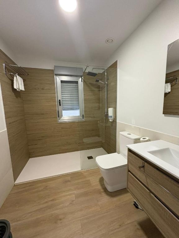 a bathroom with a shower and a toilet and a sink at Apartamentos O Grove Awa Bay in O Grove