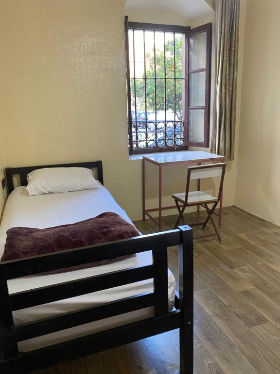 a bedroom with a bed and a window and a table at Private Room in Kasbah - Old Medina 1 in Tangier