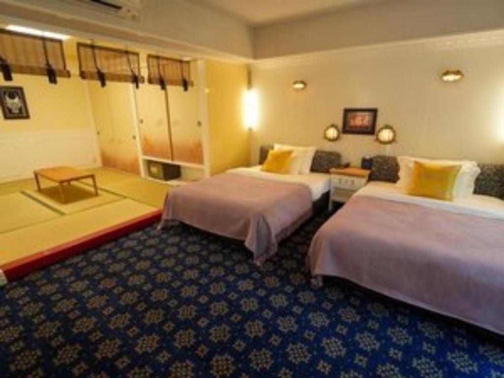 a hotel room with two beds and a couch at YAMANO RESORT HOTEL EIGHE - Vacation STAY 20058v in Shiozawa