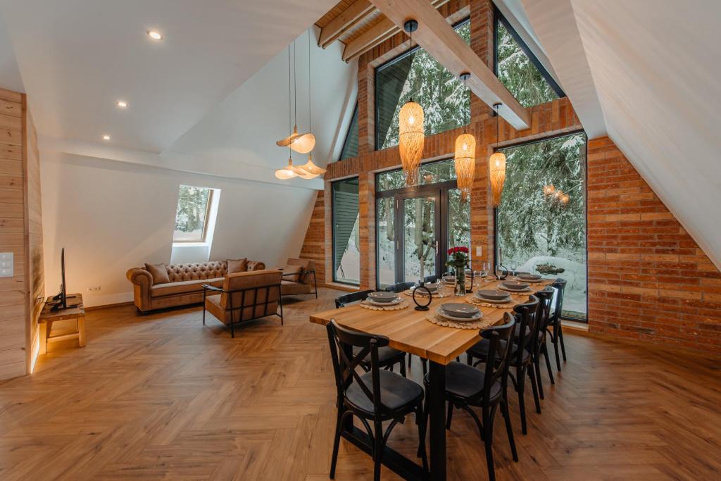 a dining room with a long table and chairs at Black Raven Cabin in Topliţa