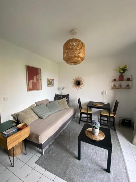 un salon avec un lit et une table dans l'établissement Nid douillet, à Ouistreham
