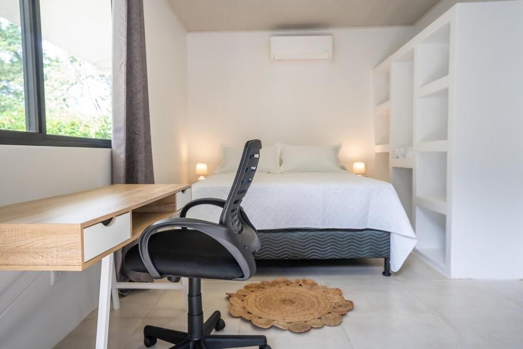 a bedroom with a bed and a desk and a chair at Mango Coliving Apartments for Digital Nomads in Uvita