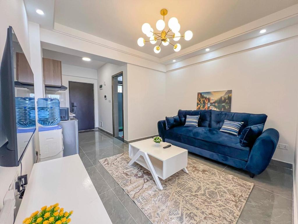 a living room with a blue couch and a table at Iconic 1Br in Riverside with views and gym in Nairobi