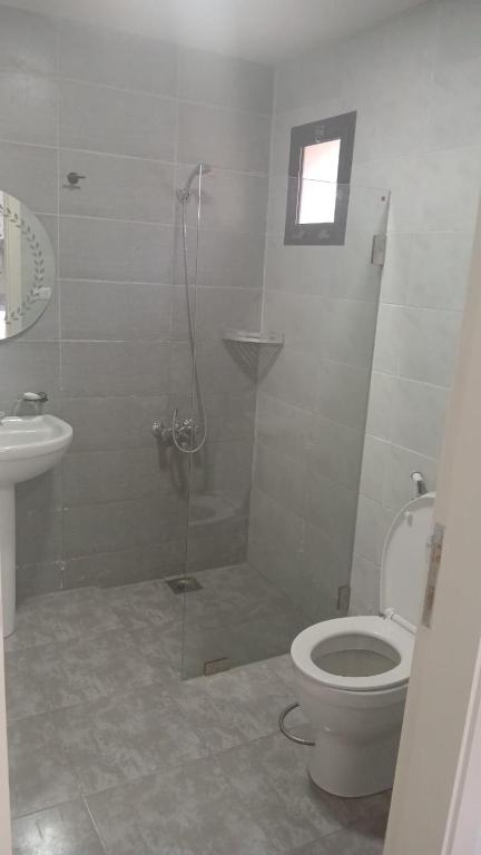 a bathroom with a shower with a toilet and a sink at La MAISON DU VAL in Jbeil
