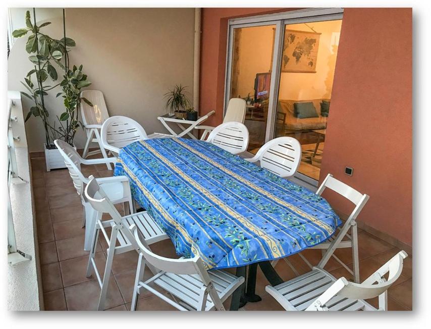 - une table avec des chaises blanches et une couverture bleue dans l'établissement L'Impérial, à Saint-Raphaël