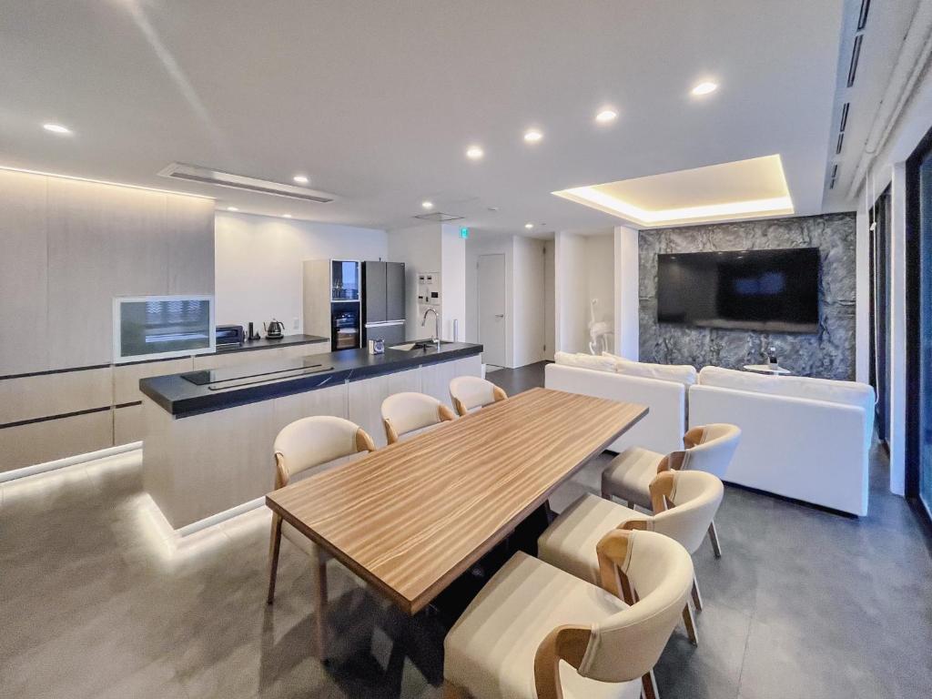 a kitchen and dining room with a wooden table and chairs at CORAL RESORT VILLA atsuhama - Vacation STAY 21312v in Sumoto