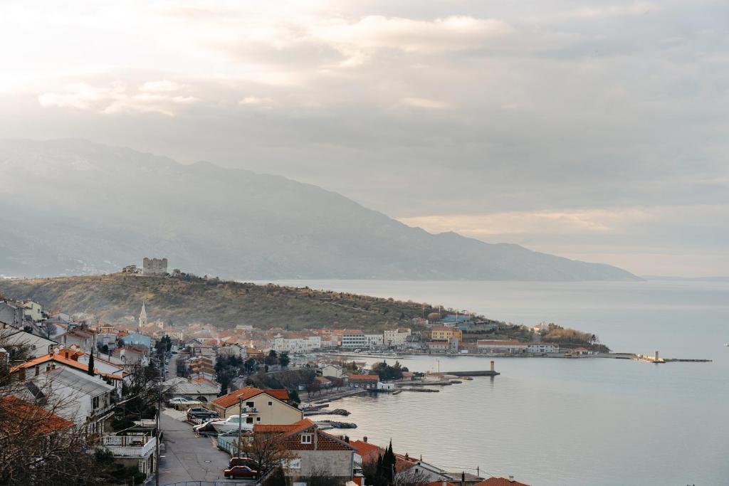 a town on a hill next to a body of water at Apartments Panorama in Senj