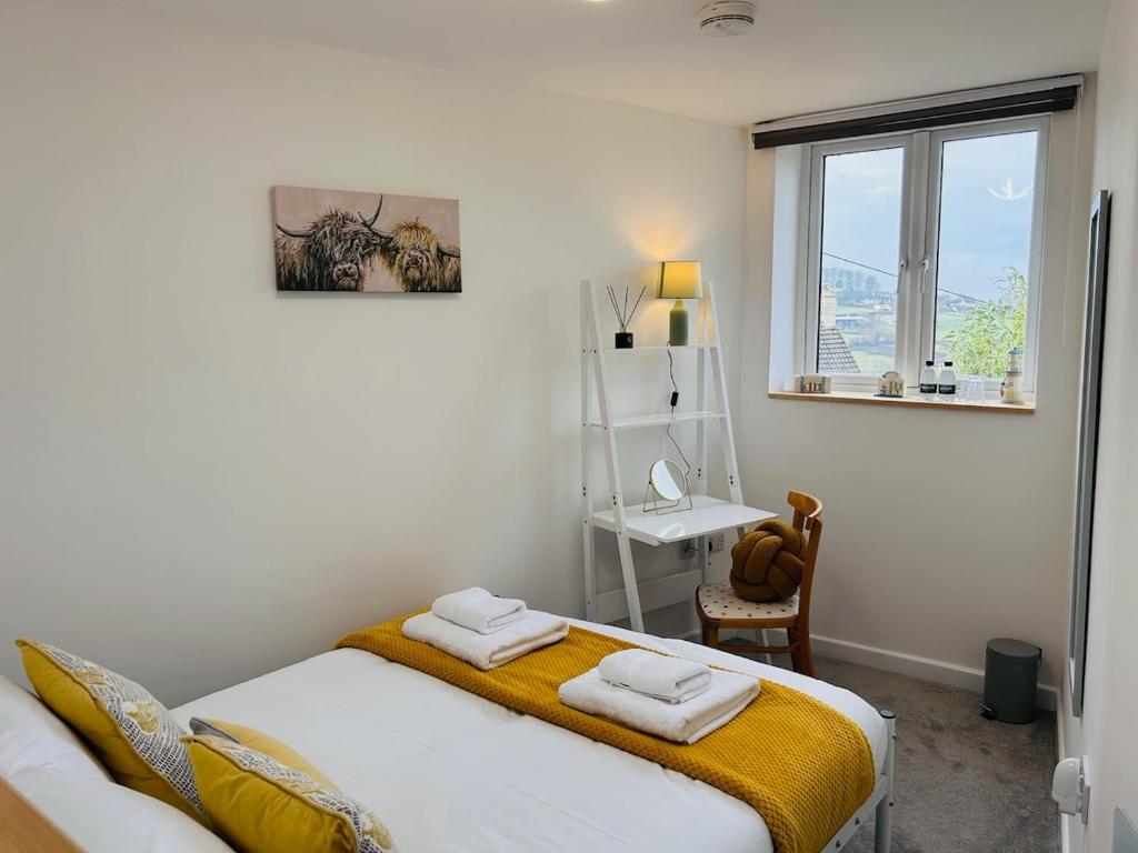 a bedroom with a bed and a desk and a window at The Old Post Office - MaisonPro in Stroud