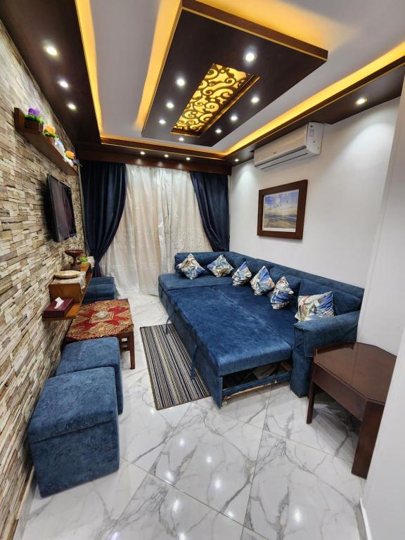 a living room with a blue bed and a couch at Porto said بورتوسعيد شاليه غرفه وصاله للأسر فقط in `Ezbet Shalabi el-Rûdi