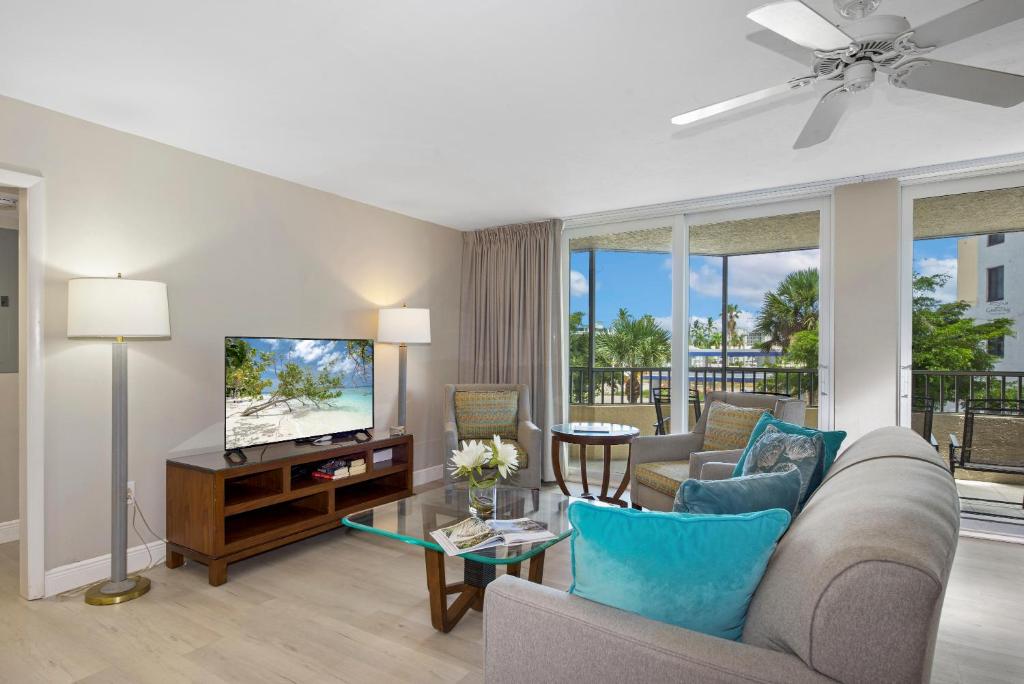 a living room with a couch and a tv at Gullwing #203 by Sun Palace Vacations in Fort Myers Beach