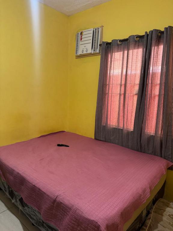 a small bed in a room with a window at Casa de temporada a 10 metros da praia in Cabo Frio