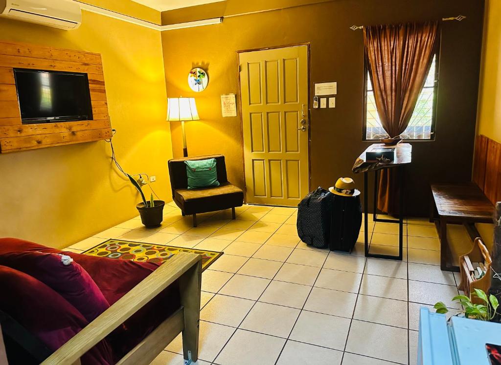 a yellow living room with a couch and a chair at City Garden 2 Apartment in Belize City