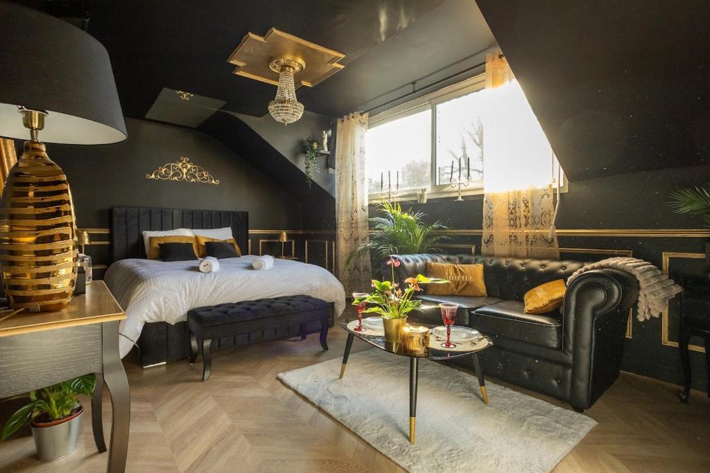 a bedroom with a bed and a couch and a table at Le Glam Divin in Nantes