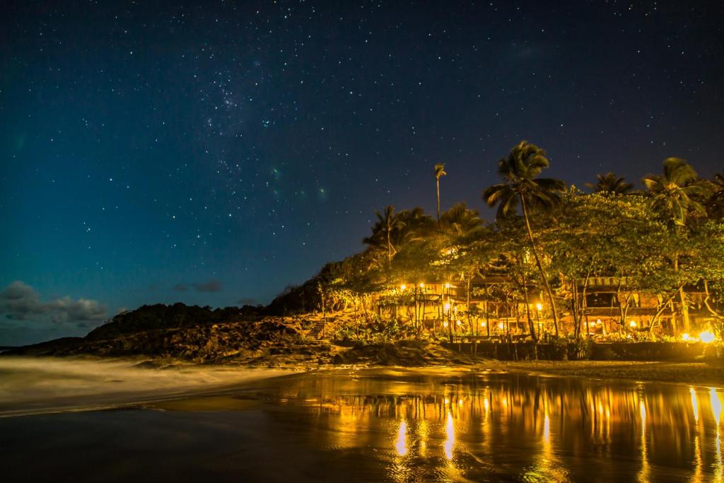 uma vista nocturna de um resort na praia em Pousada Sage Point em Itacaré