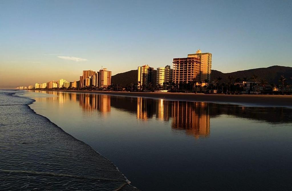 a city with tall buildings on the shore of a body of water at Apartamento a 50m da praia in Praia Grande