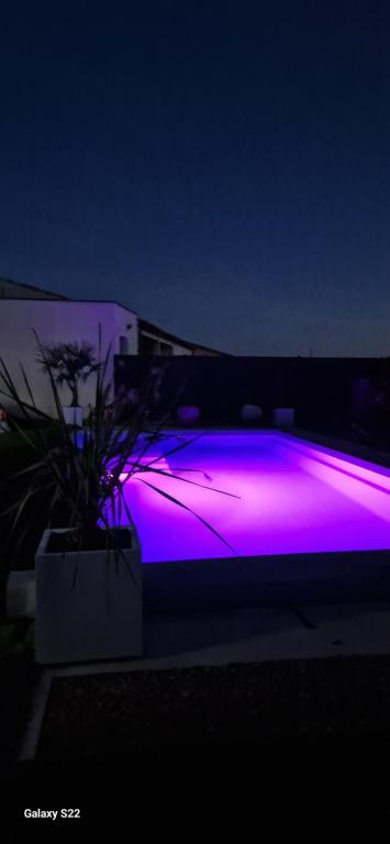 une lumière violette sur un bâtiment la nuit dans l'établissement Villa moderne avec piscine privée, à Roubia