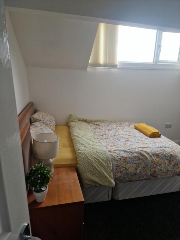 Un dormitorio pequeño con dos camas y una ventana. en En-Suite Double Room in Haughton Green Denton M34, en Haughton Green