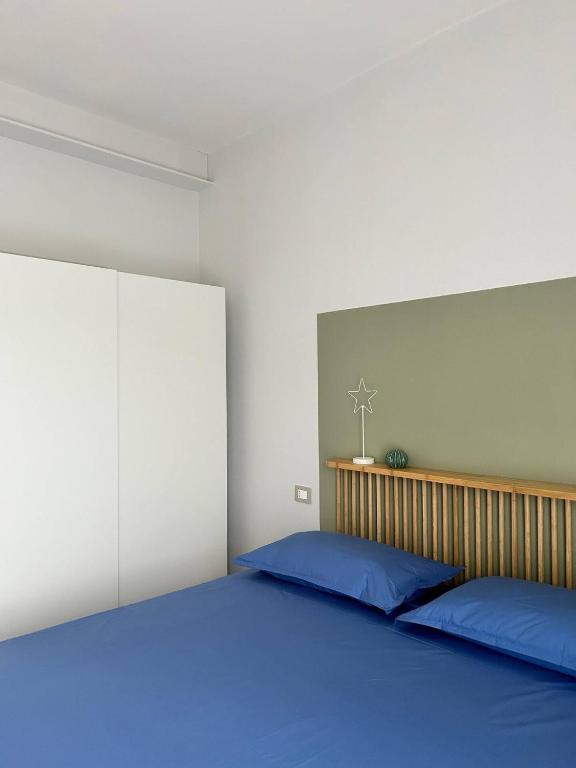 a bedroom with a large bed with blue pillows at Casa I Merletti in Lunano
