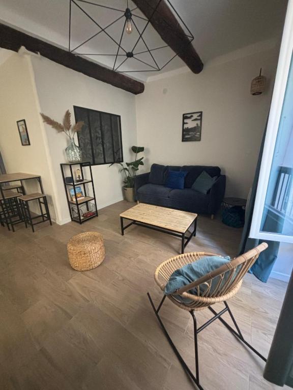 un salon avec un canapé bleu et une table dans l'établissement T2 centre historique la Ciotat, à La Ciotat