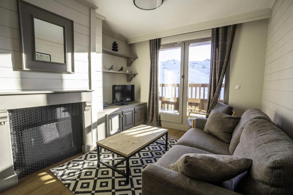 un salon avec un canapé et une cheminée dans l'établissement Chalet Rosael - Appartement plein sud au pied des pistes MAE-1561, à Val Thorens