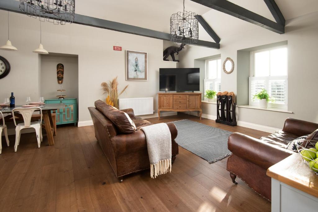 a living room with leather furniture and a dining room at Hide hill ,2 bedroom central apartment in Berwick-Upon-Tweed