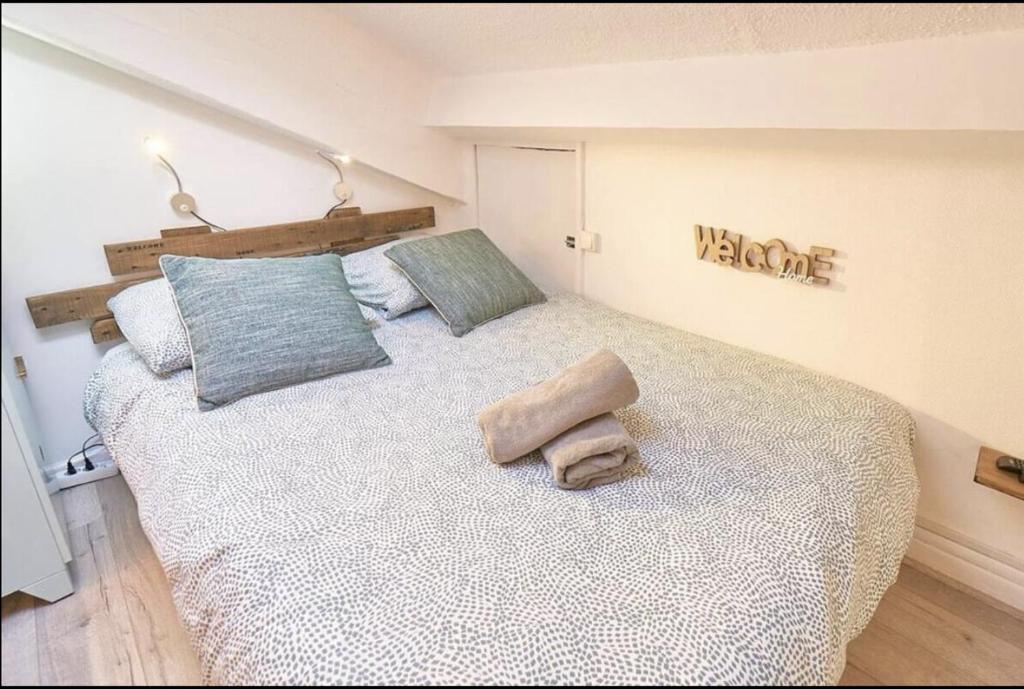 - une chambre avec un grand lit et un panneau de bienvenue sur le mur dans l'établissement Sweet Wilson Salengro - droit, à Villeurbanne
