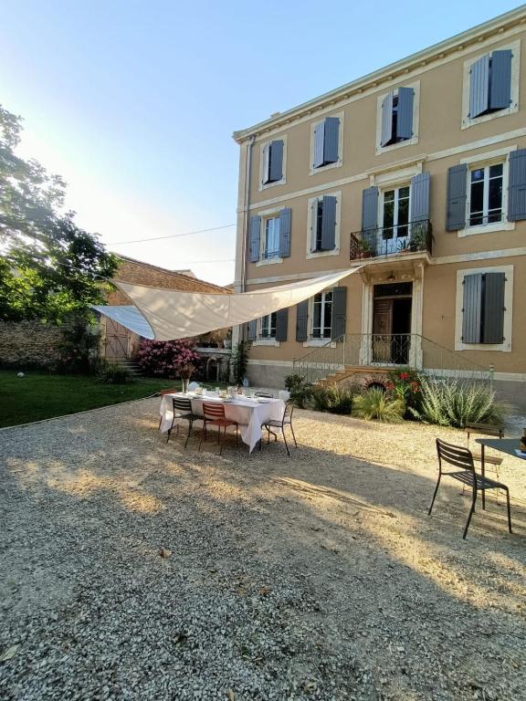 une table et des chaises devant un bâtiment dans l'établissement Eine Magnanerie in der Provence, à Bouchet