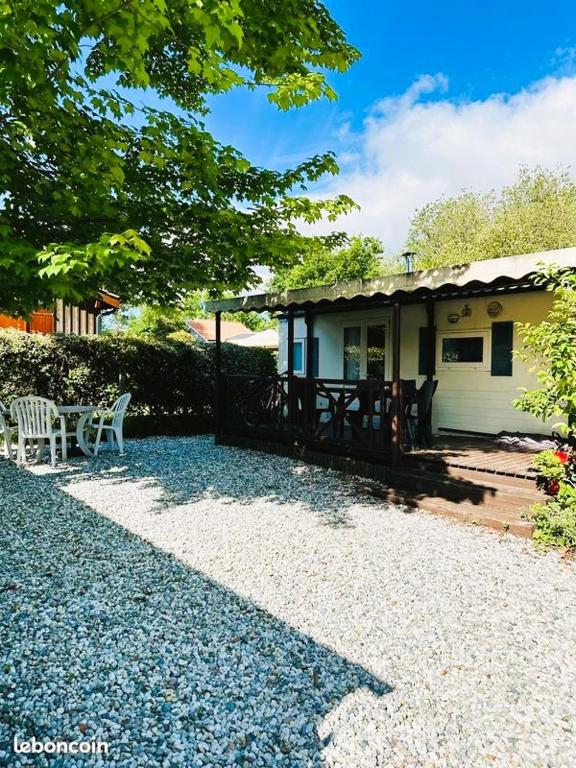 une maison avec une table et un banc devant elle dans l'établissement Mobil Home Climatisé Menthe à l'eau, à Biscarrosse