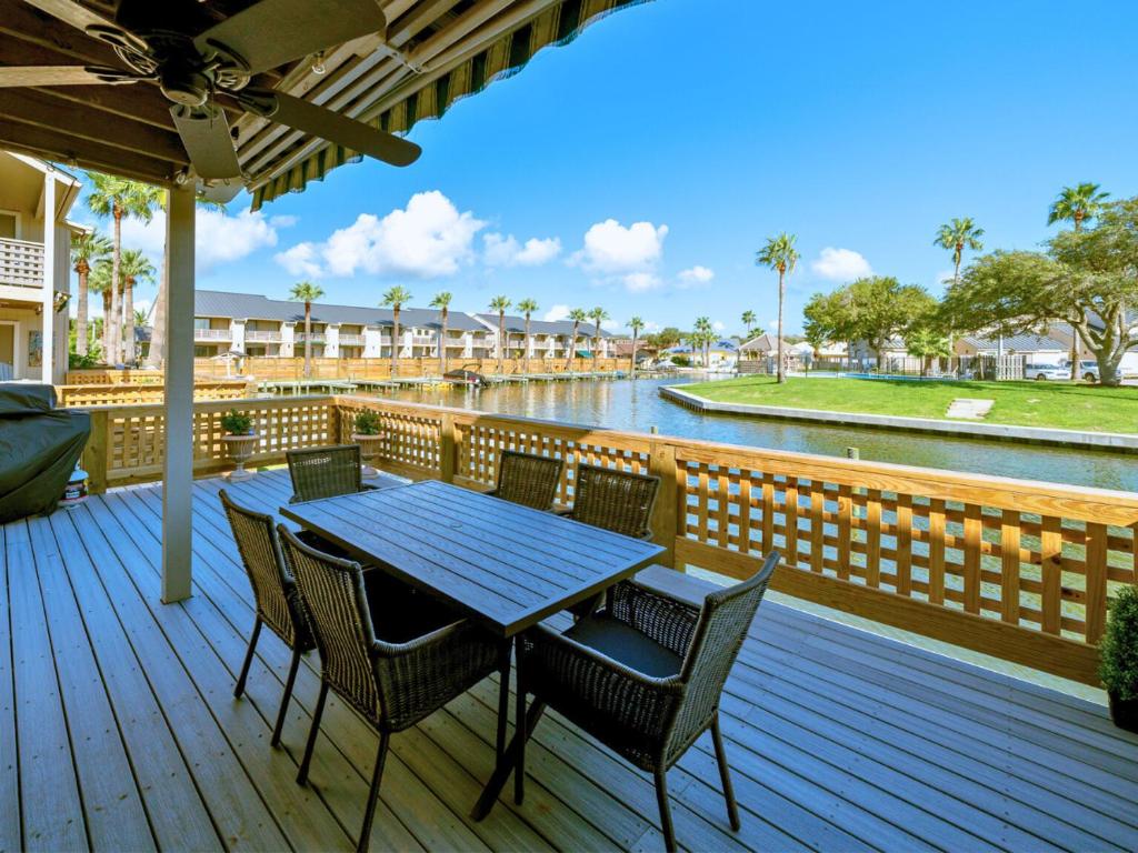 Una terraza de madera con mesa y sillas y un río. en The BS Lake House, en Rockport