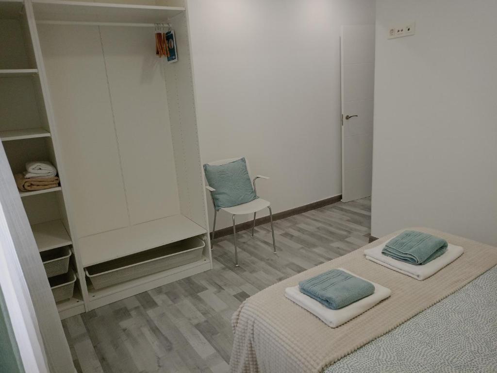 a room with two beds and a chair in it at Piso nuevo a 10 minutos de San Sebastián in Lasarte