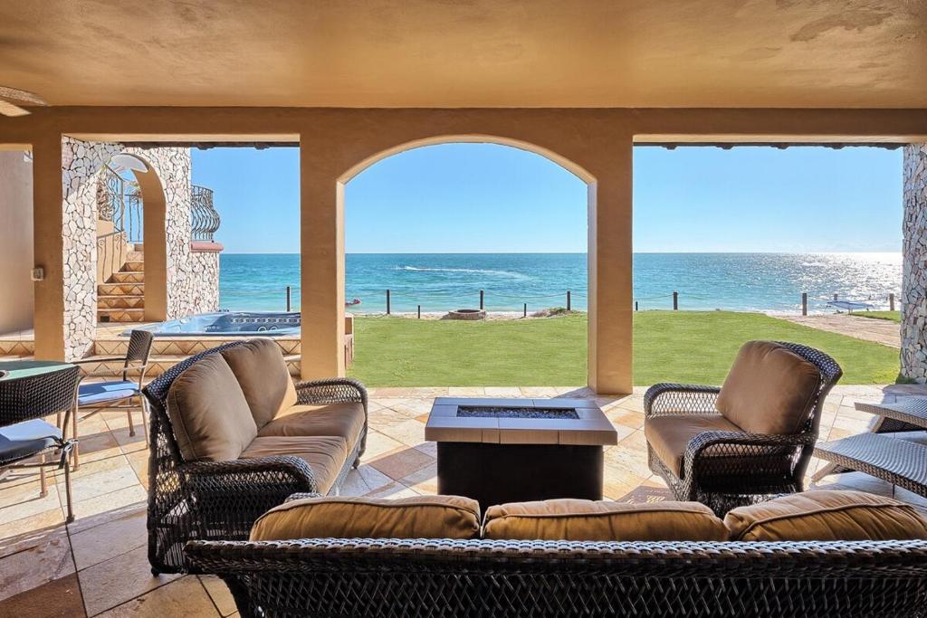 a living room with a couch and chairs and the ocean at Villa Catalina at Bella Sirena - Private Jacuzzi - On the water in Puerto Peñasco