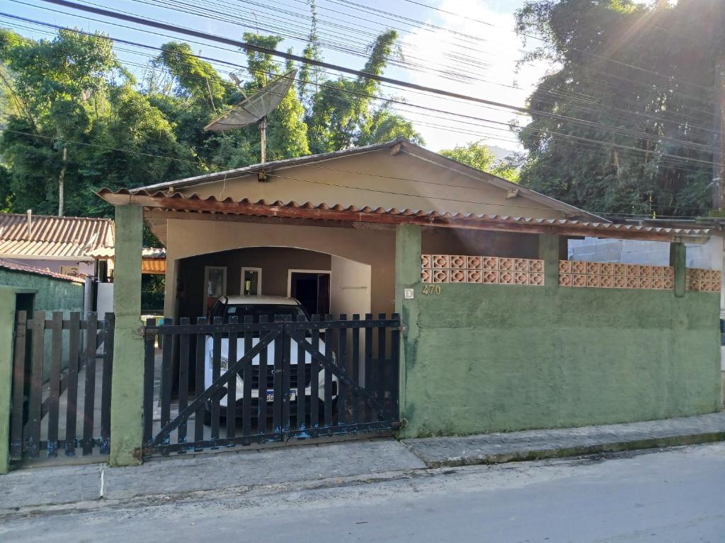 una pequeña casa con una puerta y una valla en Casa de Praia Ubatuba, en Ubatuba