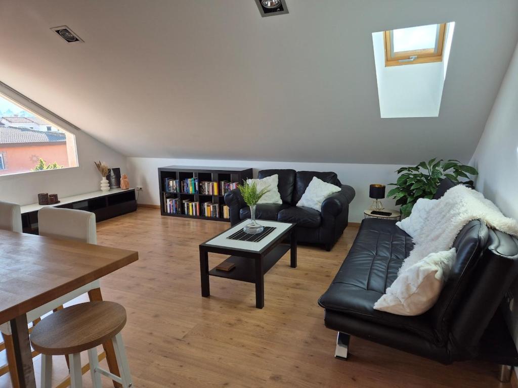 a living room with a black leather couch and a table at Penthouse Villa Alboran in Dílar