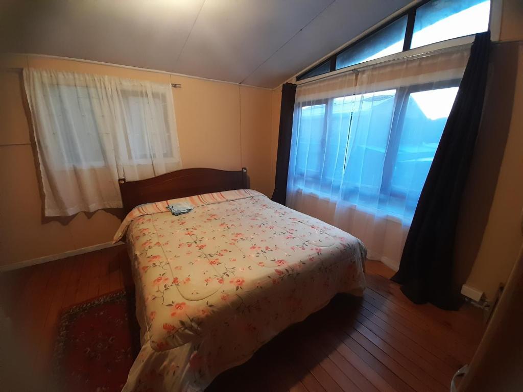 a small bedroom with a bed and a window at cabaña casa amoblada in Puerto Montt