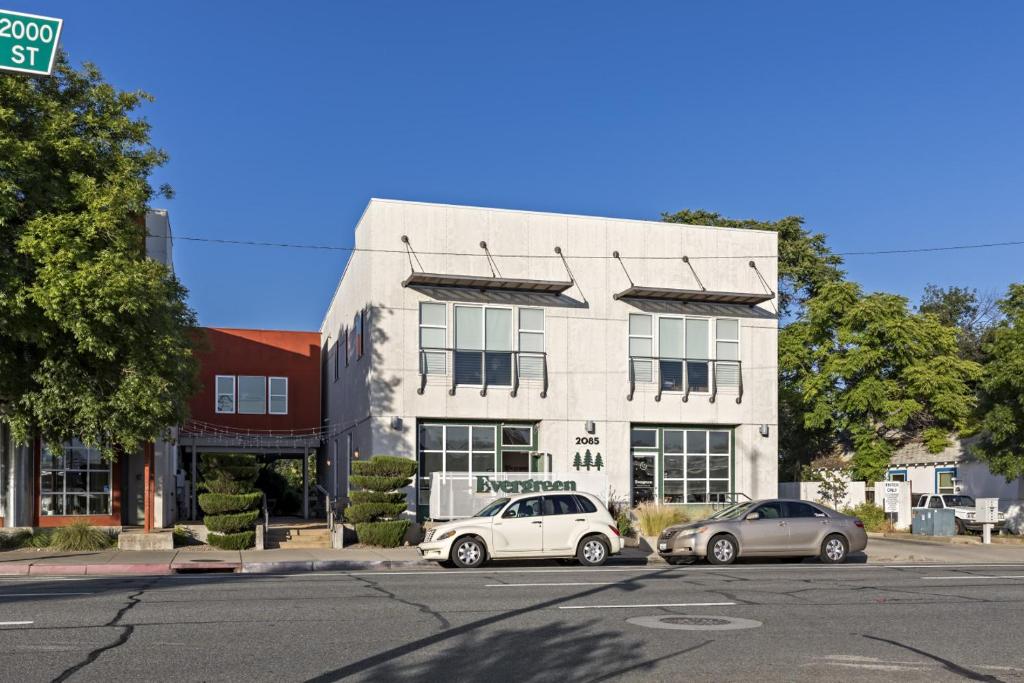 two cars parked in front of a white building at Gardenia at Evergreen in Redding