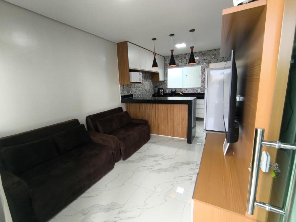 a living room with a couch and a kitchen at Casa para temporada 2-Rio da ville in Porto Seguro