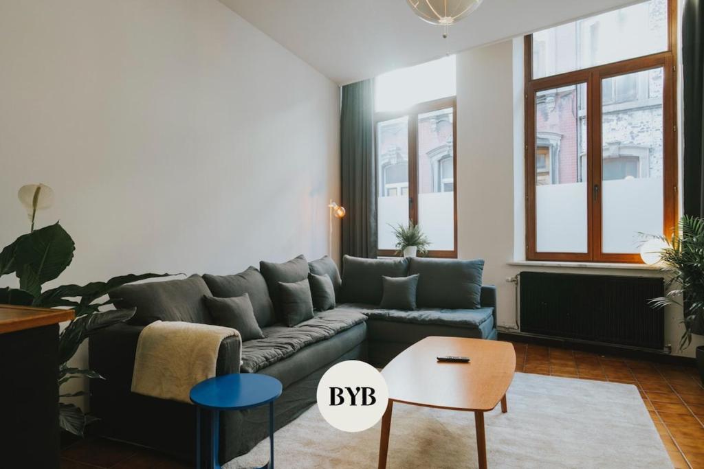 a living room with a couch and a table at 2 bedroom apartment near the city center in Liège
