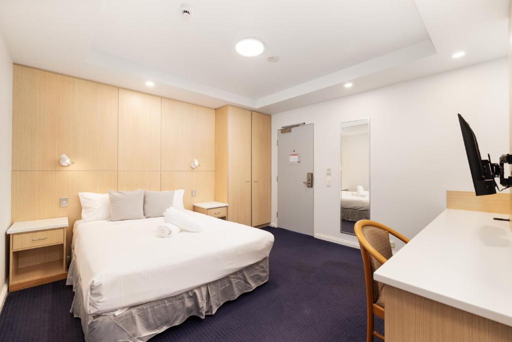 a hotel room with a bed and a desk at Asraport Motel in Brisbane