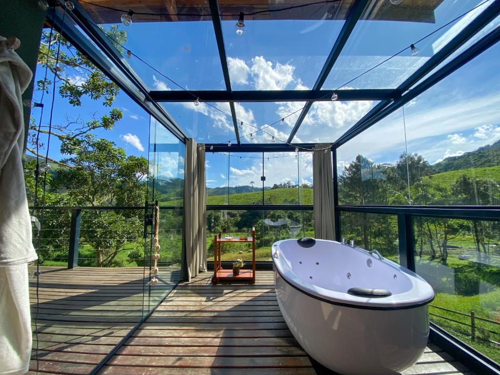 a large bathroom with a tub on a deck at Cabana Mantiká in Sapucaí-Mirim