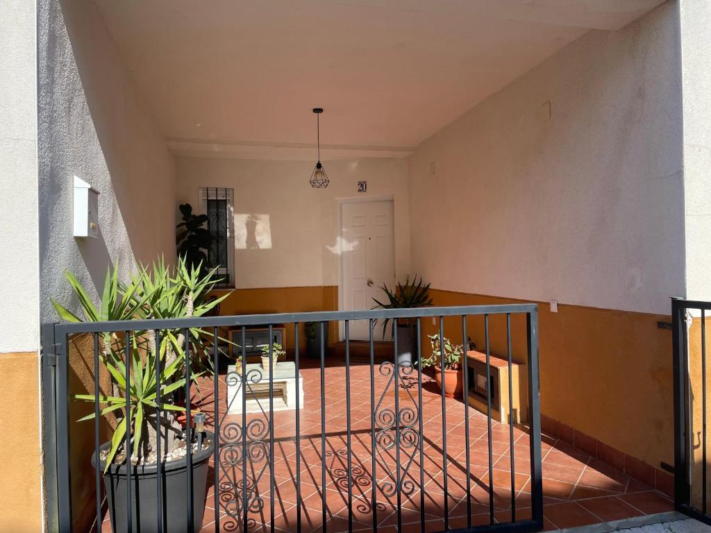 a hallway with potted plants on a balcony at Casa Rural Las Candelas in San Vicente de Alcántara