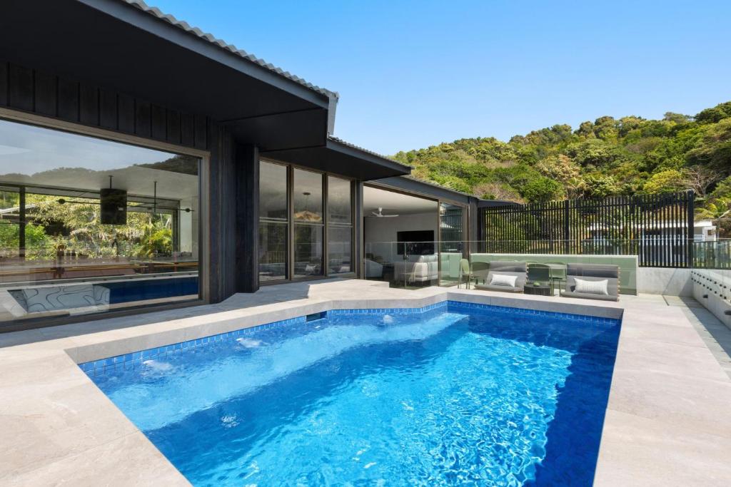 una casa con piscina delante de una casa en Solar Eclipse, en Byron Bay