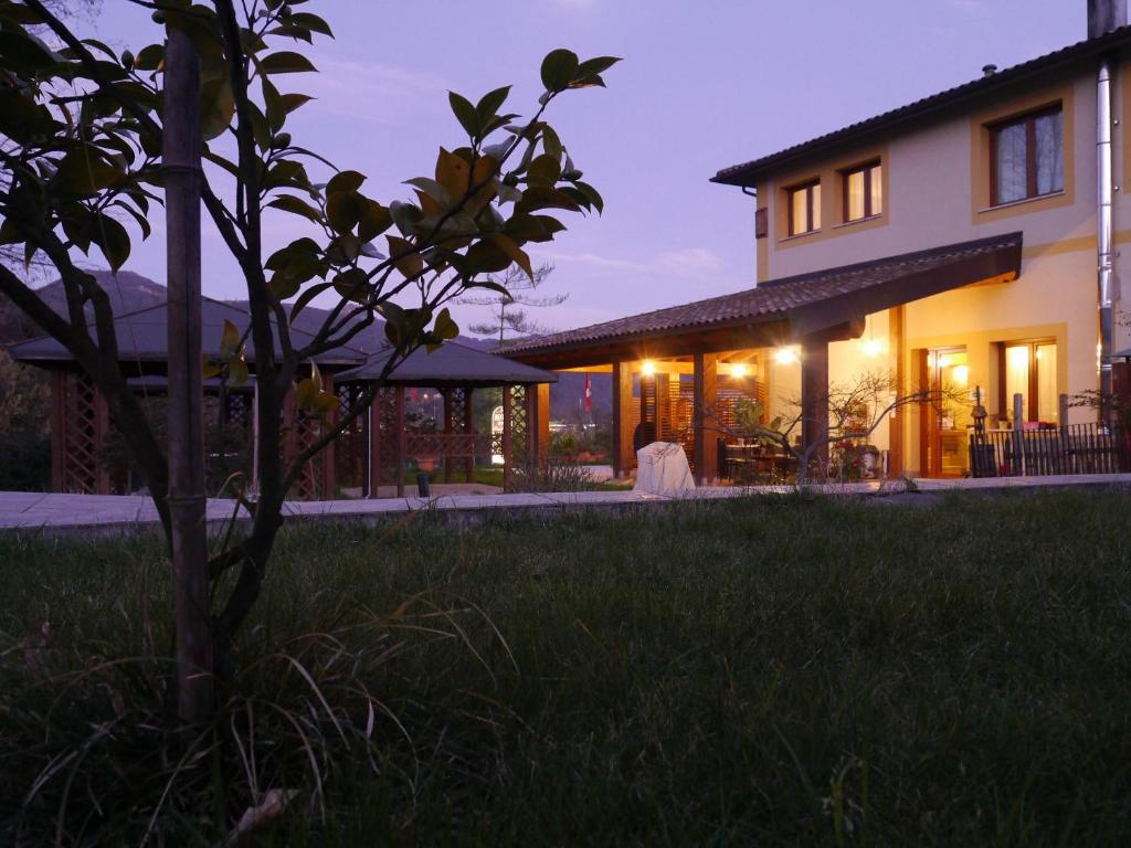 uma casa com um relvado à frente à noite em Hotel Sonno D'Autore em Borghetto di Vara